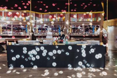 Miniature Cabaret Sauvage - Cocktail Terrasse extérieure avec tables rondes, chaises pliantes et guirlandes lumineuses suspendues, ambiance en soirée.