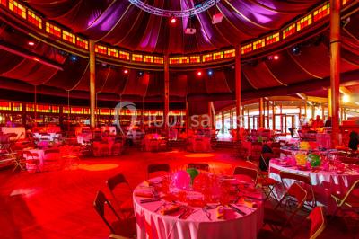 Miniature Cabaret Sauvage - Diner assis Terrasse extérieure avec tables rondes, chaises pliantes et guirlandes lumineuses suspendues, ambiance en soirée.