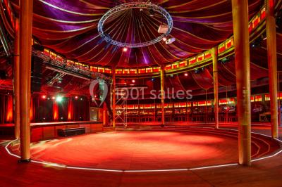 Miniature Cabaret Sauvage - Plénière Terrasse extérieure avec tables rondes, chaises pliantes et guirlandes lumineuses suspendues, ambiance en soirée.
