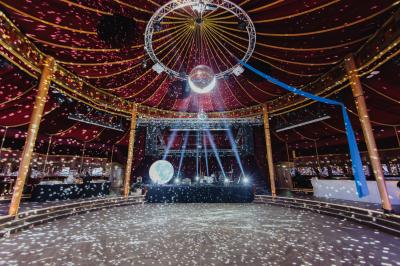 Miniature Cabaret Sauvage - Soirée dansante Terrasse extérieure avec tables rondes, chaises pliantes et guirlandes lumineuses suspendues, ambiance en soirée.