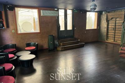 Décoration d'anniversaire avec ballons colorés, fond végétal, et personnages de dessin animé dans une salle festive.