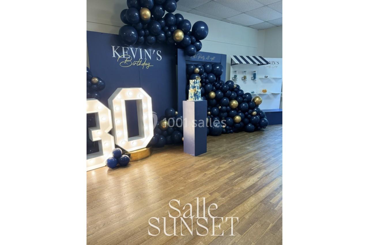 Décoration d'anniversaire avec ballons bleu marine et dorés, chiffre lumineux ’30’ et présentoir à gâteau.
