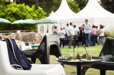 Salle lumineuse avec décoration naturelle, comprenant un canapé en bois, une table en tronc d'arbre et des chaises colorées.