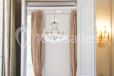 Salle lumineuse avec décoration naturelle, comprenant un canapé en bois, une table en tronc d'arbre et des chaises colorées.