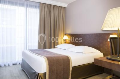 Salle lumineuse avec décoration naturelle, comprenant un canapé en bois, une table en tronc d'arbre et des chaises colorées.