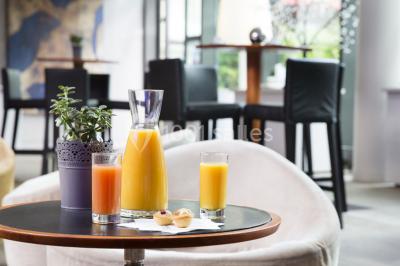 Salle lumineuse avec décoration naturelle, comprenant un canapé en bois, une table en tronc d'arbre et des chaises colorées.
