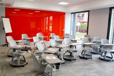 Salle lumineuse avec décoration naturelle, comprenant un canapé en bois, une table en tronc d'arbre et des chaises colorées.