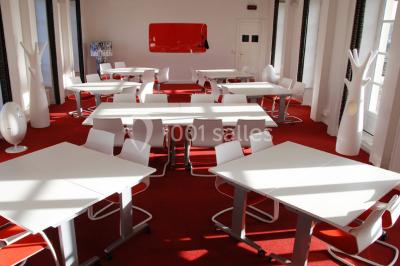 Salle lumineuse avec décoration naturelle, comprenant un canapé en bois, une table en tronc d'arbre et des chaises colorées.