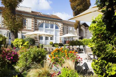 Salle lumineuse avec décoration naturelle, comprenant un canapé en bois, une table en tronc d'arbre et des chaises colorées.
