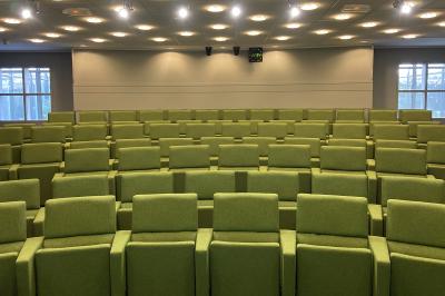 Salle lumineuse avec décoration naturelle, comprenant un canapé en bois, une table en tronc d'arbre et des chaises colorées.