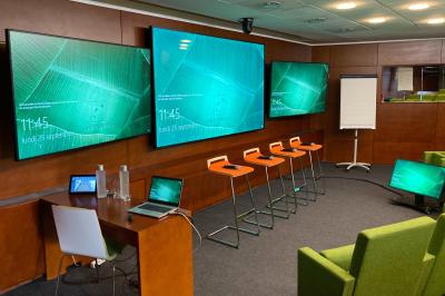 Salle lumineuse avec décoration naturelle, comprenant un canapé en bois, une table en tronc d'arbre et des chaises colorées.