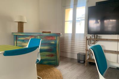 Salle lumineuse avec décoration naturelle, comprenant un canapé en bois, une table en tronc d'arbre et des chaises colorées.