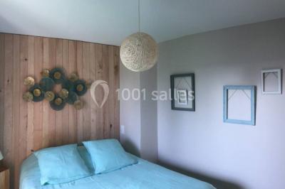 Bouquet de roses roses posé sur une surface blanche avec deux alliances dorées au premier plan.