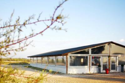Maison blanche aux volets bleus éclairée la nuit, entourée d'arbres et d'une pelouse.