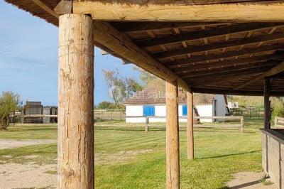 Maison blanche aux volets bleus éclairée la nuit, entourée d'arbres et d'une pelouse.