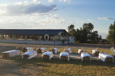 Maison blanche aux volets bleus éclairée la nuit, entourée d'arbres et d'une pelouse.