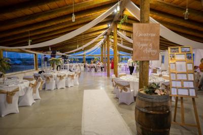 Maison blanche aux volets bleus éclairée la nuit, entourée d'arbres et d'une pelouse.