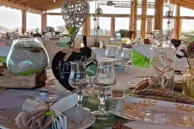 Maison blanche aux volets bleus éclairée la nuit, entourée d'arbres et d'une pelouse.