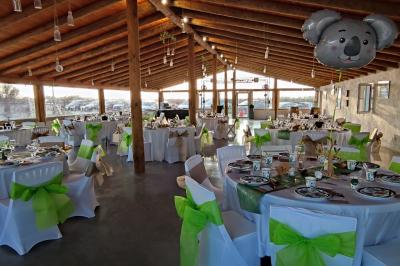 Maison blanche aux volets bleus éclairée la nuit, entourée d'arbres et d'une pelouse.
