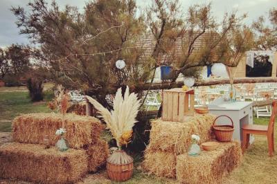 Maison blanche aux volets bleus éclairée la nuit, entourée d'arbres et d'une pelouse.