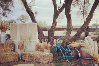 Maison blanche aux volets bleus éclairée la nuit, entourée d'arbres et d'une pelouse.
