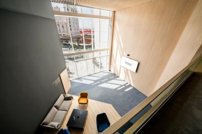 Terrasse extérieure avec mobilier de jardin, vue sur des bâtiments modernes et ciel dégagé en arrière-plan.