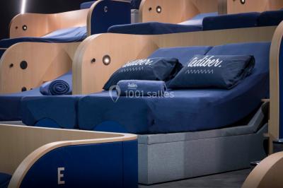 Terrasse extérieure avec mobilier de jardin, vue sur des bâtiments modernes et ciel dégagé en arrière-plan.