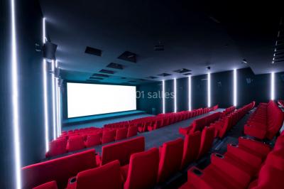 Terrasse extérieure avec mobilier de jardin, vue sur des bâtiments modernes et ciel dégagé en arrière-plan.