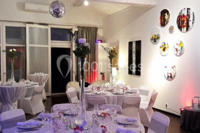 Voiture blanche décorée de fleurs garée devant une maison moderne avec jardin et clôture en métal.