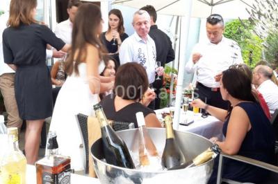 Voiture blanche décorée de fleurs garée devant une maison moderne avec jardin et clôture en métal.