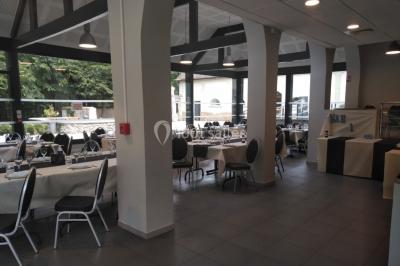 Tables dressées avec des ustensiles de cuisine, planches vertes et ingrédients, dans une salle lumineuse.