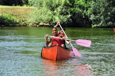 Tables dressées avec des ustensiles de cuisine, planches vertes et ingrédients, dans une salle lumineuse.