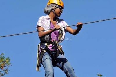 Tables dressées avec des ustensiles de cuisine, planches vertes et ingrédients, dans une salle lumineuse.