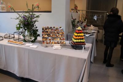 Tables dressées avec des ustensiles de cuisine, planches vertes et ingrédients, dans une salle lumineuse.