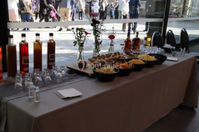 Tables dressées avec des ustensiles de cuisine, planches vertes et ingrédients, dans une salle lumineuse.