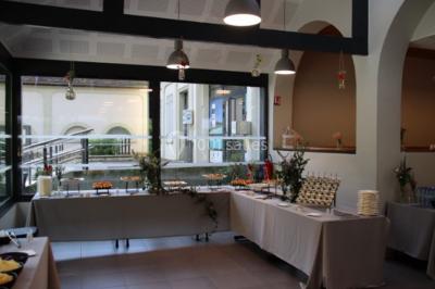 Tables dressées avec des ustensiles de cuisine, planches vertes et ingrédients, dans une salle lumineuse.