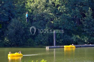 Tables dressées avec des ustensiles de cuisine, planches vertes et ingrédients, dans une salle lumineuse.
