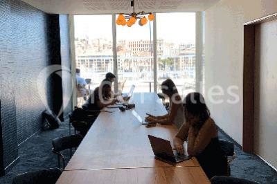 Mur végétal avec plantes vertes en arrière-plan, deux femmes assises, l'une travaillant sur un ordinateur portable.