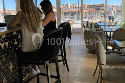 Mur végétal avec plantes vertes en arrière-plan, deux femmes assises, l'une travaillant sur un ordinateur portable.
