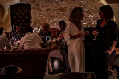 Miniature Location salle Mérindol (Vaucluse) - La Cave à Aimé #3 Bouteilles de spiritueux variés et verres servis sur un tonneau dans un cadre chaleureux de bar ou cave.