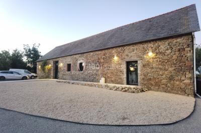Assiette contenant des cookies et un petit gâteau sur une table noire, avec des verres et un vase décoratif à proximité.