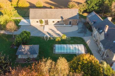 Assiette contenant des cookies et un petit gâteau sur une table noire, avec des verres et un vase décoratif à proximité.