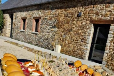 Assiette contenant des cookies et un petit gâteau sur une table noire, avec des verres et un vase décoratif à proximité.