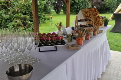Assiette contenant des cookies et un petit gâteau sur une table noire, avec des verres et un vase décoratif à proximité.