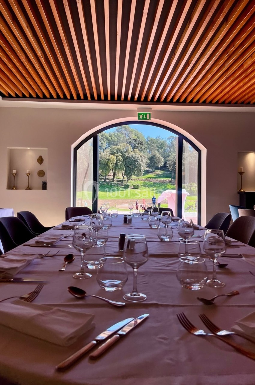 Location salle Marseille 11 (Bouches-du-Rhône) - La Bastide de la Salette #4 Salle de restaurant lumineuse avec table dressée, vue sur un jardin verdoyant à travers une grande baie vitrée.