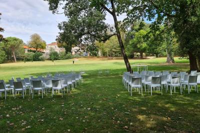 Salle de réception décorée avec des tables rondes recouvertes de nappes rouges, ornées de compositions florales.