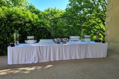 Salle de réception décorée avec des tables rondes recouvertes de nappes rouges, ornées de compositions florales.