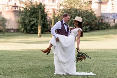Salle de réception décorée avec des tables rondes recouvertes de nappes rouges, ornées de compositions florales.