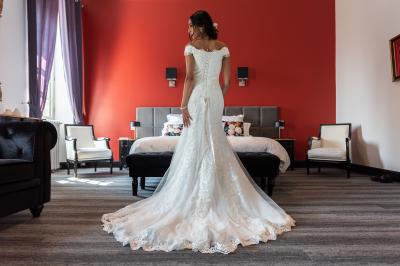 Salle de réception décorée avec des tables rondes recouvertes de nappes rouges, ornées de compositions florales.