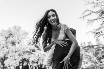 Salle de réception décorée avec des tables rondes recouvertes de nappes rouges, ornées de compositions florales.